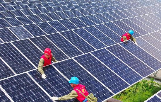 State Grid employees check solar power panels in the Tibet autonomous region. (Photo: China Daily/Song WeiXing)