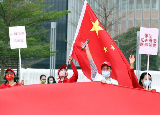 Citizens display China's national flag in support of implementing the principle of 