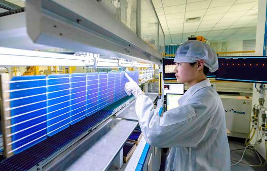 A technician checks out solar panels at a company in Hefei, Anhui province.  (Photo/China Daily)