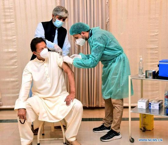 Pakistani Prime Minister Imran Khan (L) receives a dose of COVID-19 vaccine in Islamabad, Pakistan, March 18, 2021. Days after Pakistani president received a Sinopharm vaccine jab, Pakistani Prime Minister Imran Khan on Thursday also received his COVID-19 jab with Sinopharm vaccine. (Press Information Department of Pakistan/Handout via Xinhua)