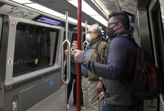 People wearing face masks are seen on an airport express train in Seattle, the United States, March 14, 2021. (Xinhua/Wu Xiaoling)