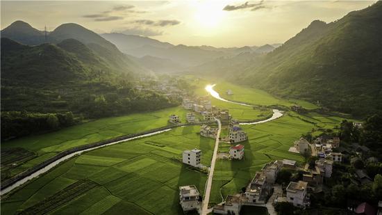 The sun sets on Jinxing village in Chengbu Miao ethnic autonomous county, Hunan province. Chengbu was removed from the list of impoverished counties at the beginning of last year, having become a booming tourism and agricultural center. （Photo provided to China Daily）