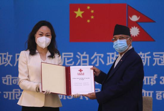 Chinese Ambassador to Nepal Hou Yanqi (L) gives the COVID-19 vaccine handover document to Prime Minister of Nepal KP Sharma Oli at the prime minister's residence in Kathmandu, Nepal, on March 29, 2021. (Photo by Sulav Shrestha/Xinhua)