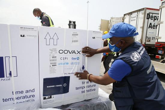 Workers transfer boxes of COVID-19 vaccines from the vaccine-sharing COVAX initiative at Abidjan International Airport in Abidjan, Cote d'Ivoire, Feb. 26, 2021. (Photo by Yvan Sonh/Xinhua)