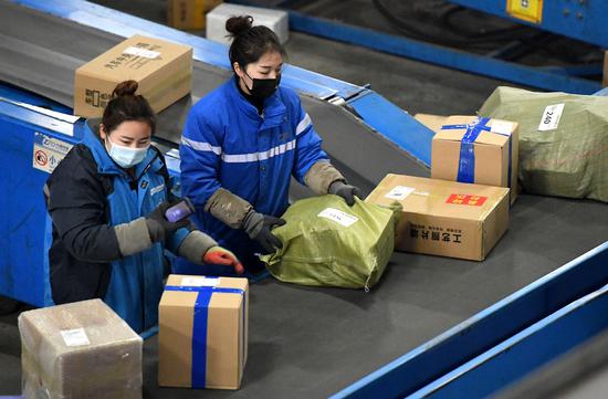 Workers sort packages at a courier company in Zhengzhou, Central China's Henan province, Jan 21, 2021. (Photo/Xinhua)