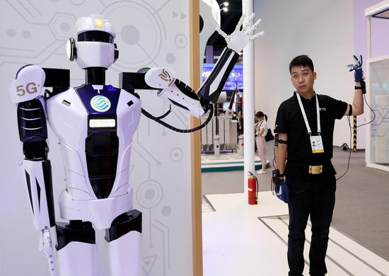 A staff member demonstrates 5G-based remote control of a robot during the 2019 World Artificial Intelligence Conference in Shanghai, Aug. 29, 2019. (Xinhua/Fang Zhe)