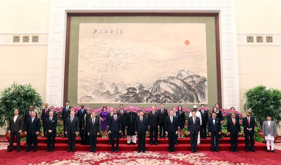 President Xi Jinping (center) poses for a group photo with 29 new ambassadors to China after he received credentials presented by the envoys at the Great Hall of the People in Beijing on Wednesday. （YAO DAWEI/XINHUA）