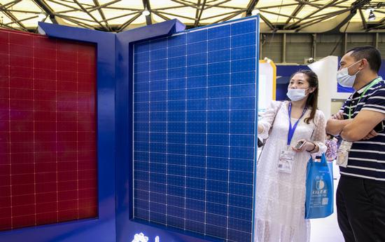 Visitors look at a solar panel during an industry expo in Shanghai.(Photo/China Daily)