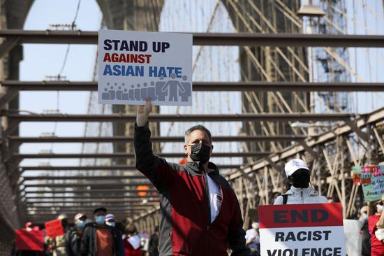 People march to protest against anti-Asian hate crimes on Brooklyn Bridge in New York, the United States, April 4, 2021. A big 