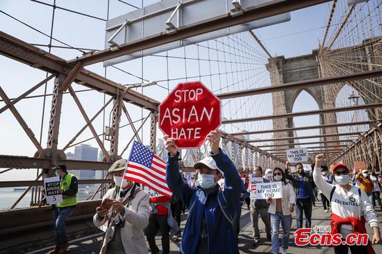 People march across the Brooklyn Bridge during a 