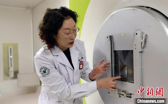 A doctor from Heavy Ion Center, Wuwei Cancer Hospital, Gansu Province, explains the principle of carbon ions treatment.  (Photo/China News Service)