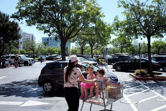 People walk to the parking lot after shopping at a supermarket in San Francisco Bay Area, California, the United States, May 4, 2021. (Xinhua/Wu Xiaoling)