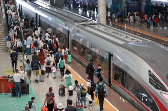 Passengers walk to board a high-speed train in Wuhan Railway Station in Wuhan, capital of central China's Hubei Province, May 5, 2021. (Photo: Xinhua/Zhao Jun)