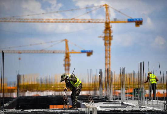 Workers labor at the construction site of Lingshui Li'An international education innovation pilot zone in Li'An peninsula of Lingshui Li Autonomous County, south China's Hainan Province, April 5, 2021. (Xinhua/Guo Cheng)