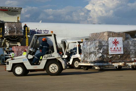 Workers transport medical supplies donated by China at the airport in Vientiane, Laos, on Monday. (ZHANG JIANHUA/XINHUA)