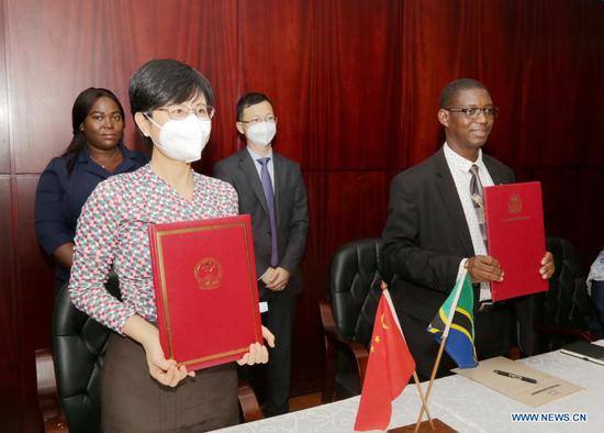 Chinese Ambassador to Tanzania Wang Ke (2nd L) and Permanent Secretary of Tanzanian Ministry of Finance and Planning Emmanuel Tutuba (1st R) show the signed agreement in Dar es Salaam, Tanzania, on May 12, 2021. China and Tanzania on Wednesday signed an agreement on economic and technical cooperation to enhance bilateral friendship. (Photo by Herman Emmanuel/Xinhua)