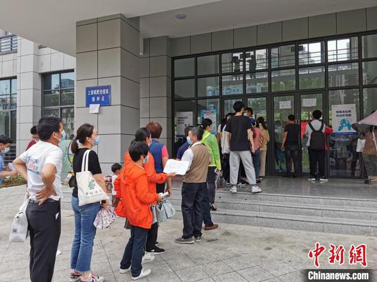 Residents are in line to get vaccinated for COVID-19, at Feixi County, east China's Anhui Province, May 14, 2021. (China News Service/Chu Weiwei)