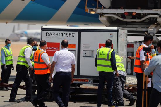 Airport staff transport the first batch of Chinese Sinovac vaccine raw materials unloaded from a palne at the Cairo International Airport in Cairo, Egypt, May 21, 2021. (Xinhua/Sui Xiankai)