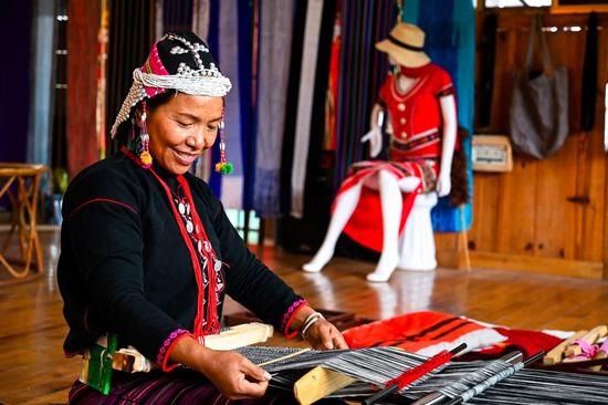 A villager makes hand-woven brocade at the Ximeng Impression, a local ethnic cultural company, in Yangluo Village of Wa Autonomous County of Ximeng, southwest China's Yunnan Province, Dec. 20, 2020.(Xinhua/Wang Guansen)