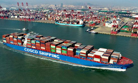 Aerial photo taken on Feb 19, 2021 shows a cargo ship pulling out at the Qianwan Container Terminal in Qingdao, East China's Shandong province. (Photo/Xinhua)