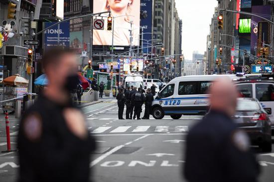 Policemen stand guard near a shooting scene in Times Square in New York, the United States, May 8, 2021. (Photo: Xinhua/Wang Ying)