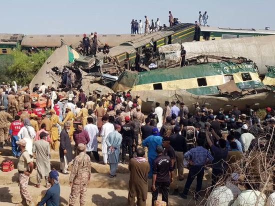 Photo taken with mobile phone shows army soldiers inspect a derailed compartment of a passenger train in Ghotki district of Pakistan's southern Sindh province on June 7, 2021. (Str/Xinhua)