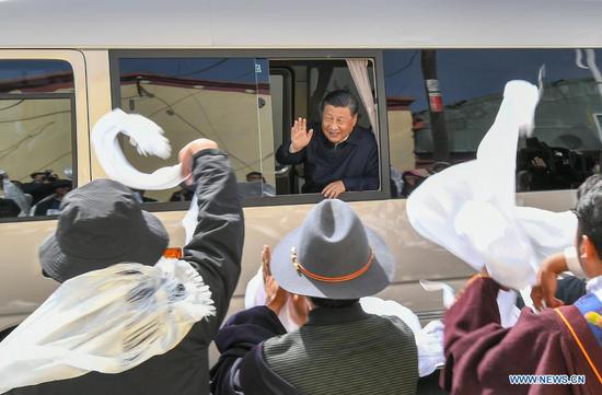 President Xi Jinping, who is also general secretary of the Communist Party of China Central Committee and chairman of the Central Military Commission, waves to local residents after visiting a village in Shaliuhe township in Gangca county of the Haibei Tibetan autonomous prefecture, Qinghai province, on Tuesday. Xi visited the county during his inspection tour of the province. (XIE HUANCHI/XINHUA)