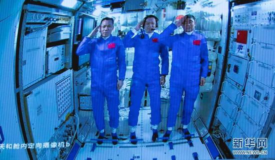 Screen image captured at Beijing Aerospace Control Center in Beijing, capital of China, June 17, 2021 shows three Chinese astronauts onboard the Shenzhou-12 spaceship saluting after entering the space station core module Tianhe.(Xinhua/Jin Liwang)