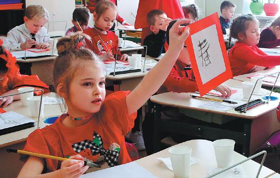 Ukrainian pupils practice Chinese calligraphy at an oriental languages school in Kiev on Feb 15. (Photo/Xinhua)