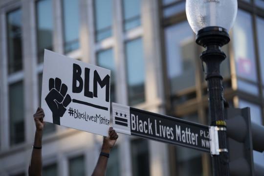 Photo taken on June 8, 2020 shows a protester holding a sign that reads 