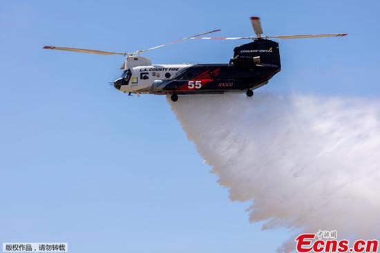 A firefighter helicopter demonstrates a water drop as officials announce a 180-day Quick Reaction Force program designed to help battle wildfires, during a media event at Joint Forces Training Base Los Alamitos in Los Alamitos, California, U.S., June 14, 2021. (photo/Agencies)