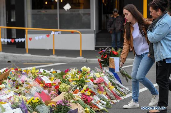 A woman places flowers to mourn the victims of the attacks on two mosques in Christchurch, New Zealand, on March 16, 2019. It was revealed that a 28-year-old Australian man, Brenton Tarrant, conducted terrorist attacks targeting mosques in Christchurch and later was arrested by New Zealand Police. At least 49 people were killed and 48 are hospitalized now. (Xinhua/Guo Lei)