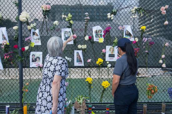 People view a makeshift memorial near the site of the residential building collapse in Miami-Dade County, Florida, the United States, on June 26, 2021. (Photo by Monica McGivern/Xinhua)