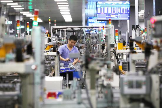 A staff member works at a workshop of microwave oven factory of Midea Group, a Chinese home appliance giant, in Foshan City, south China's Guangdong Province, April 1, 2021. (Xinhua/Li Jiale)