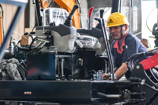 An employee works on the production line of excavators at a machinery manufacturing plant in Tai'an, Shandong province. (Photo/Xinhua)