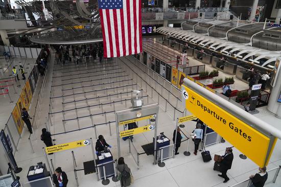 Passengers enter the security inspection area at John F. Kennedy International Airport in New York, the United States, March 13, 2020.