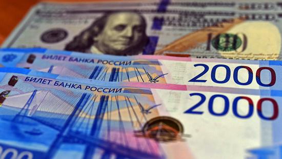 Russian ruble banknotes are seen with the U.S. dollars in the backdrop on March 2, 2021. (Xinhua/Shi Hao)