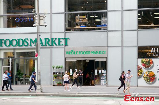 People walk past a Whole Foods Market store in New York, U.S., July 13, 2021. (Photo: China News Service/Wang Fan)