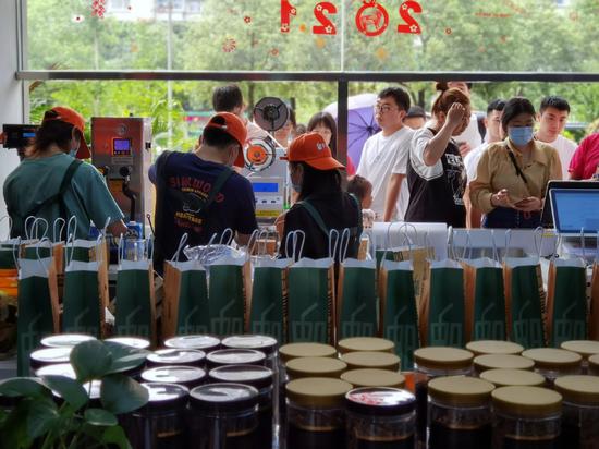 Employees of Post Oxygen of Tea prepare milk tea for customers at its store in Fuzhou, Fujian province, on June 6. (CHEN QIN/FOR CHINA DAILY)