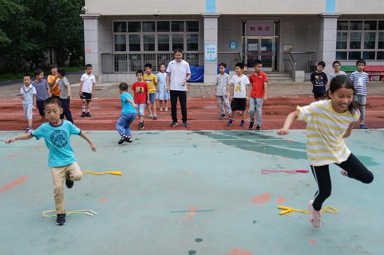 Children take part in outdoor activity with the guidance of teacher at Beijing Primary School in Beijing, capital of China, July 19, 2021. (Xinhua/Peng Ziyang)