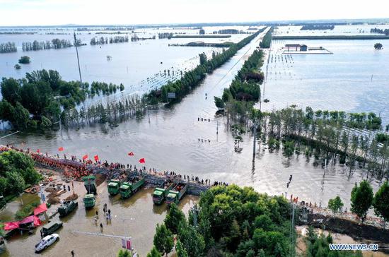 Rescuers, residents reinforce embankment at Xunxian in Henan