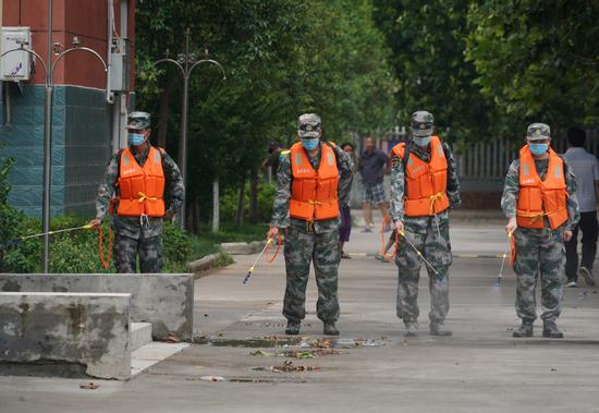 Rescuers disinfect a primary school in Weihui, Henan province, on Wednesday. The school is being used to accommodate people affected by the recent flooding in northern Henan. (Xinhua)