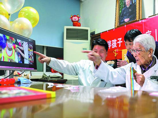 Zhang Jinzhe (right), 101, cheers up children who have tumors during a livestream session in May, ahead of Children's Day on June 1.(ZHANG YUWEI/XINHUA)