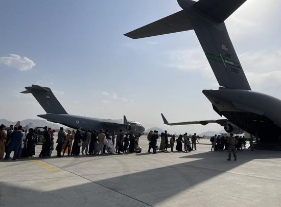 People queue up to board a military aircraft of the United States and leave Kabul at Kabul airport, Afghanistan, Aug. 22, 2021. (Xinhua)