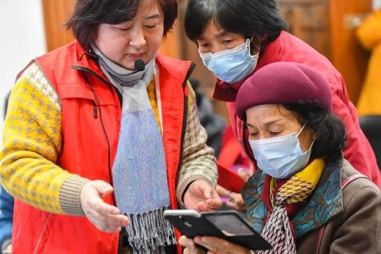 Volunteer in Changsha, Hunan province, teach elderly in a community on how to use a smartphone in August. (Photo/Xinhua)