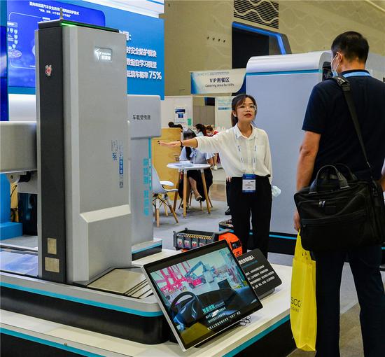 An exhibitor introduces an intelligent flexible charging robot at the World New Energy Vehicle Congress in Haikou, capital of South China's Hainan province, on Sept 15, 2021. (Photo/Xinhua)