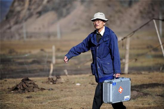 Wang Wanqing walks to treat a patient. (Photo/Xinhua)