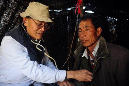 File photo taken on Oct 30, 2012 shows a doctor treats a herder. (Photo/Xinhua)