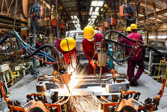 Workers weld at a workshop of an automobile manufacturing enterprise in Qingzhou city, East China's Shandong province, Feb 28, 2021. (Photo/Xinhua)