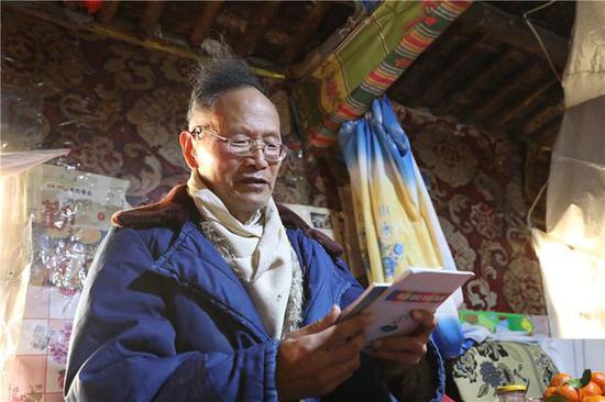 Wang Wanqing reads books at home. (Photo/Xinhua)